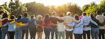 Group of people with arms around each other facing away from the camera