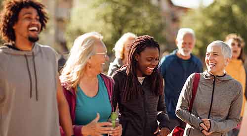 Group of people smiling and walking outdoors