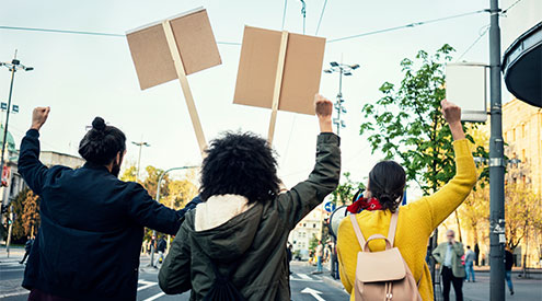 People marching in street and holding signs