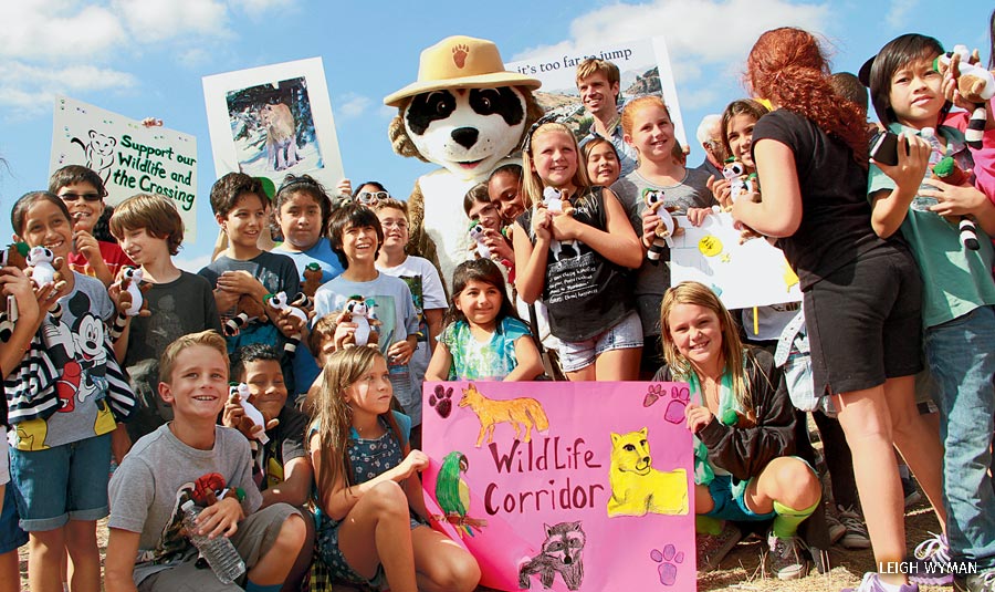 A group of people and Ranger Rick show their support for a wildlife corridor