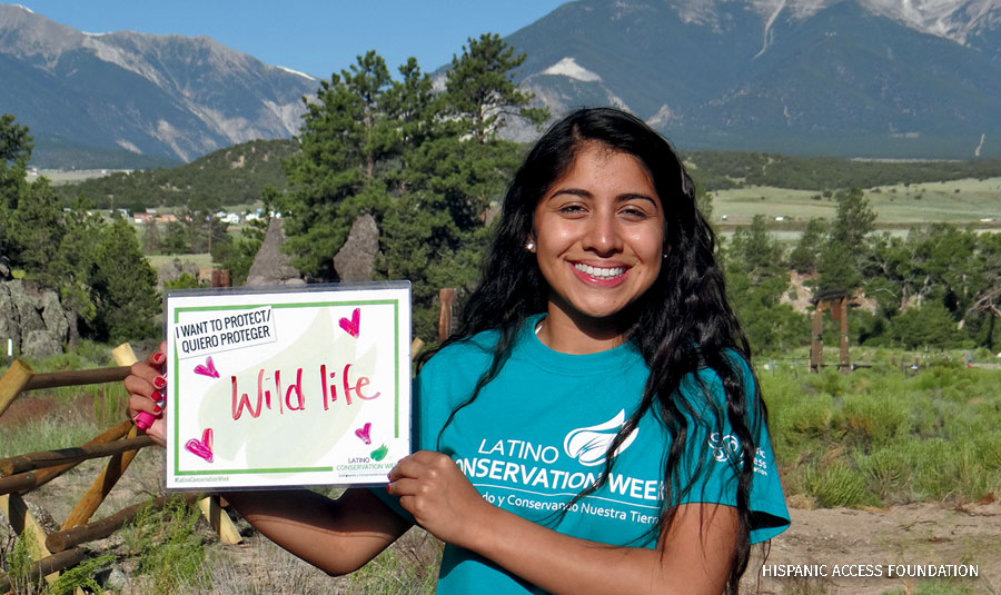 A girl holds a sign supporting wildlife