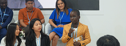 Young person holding microphone while others look on