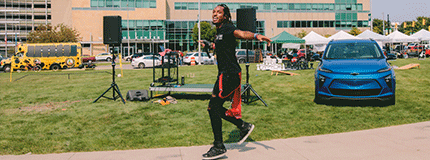 Person performing on outdoor stage in front of Wayne State University Welcome Center